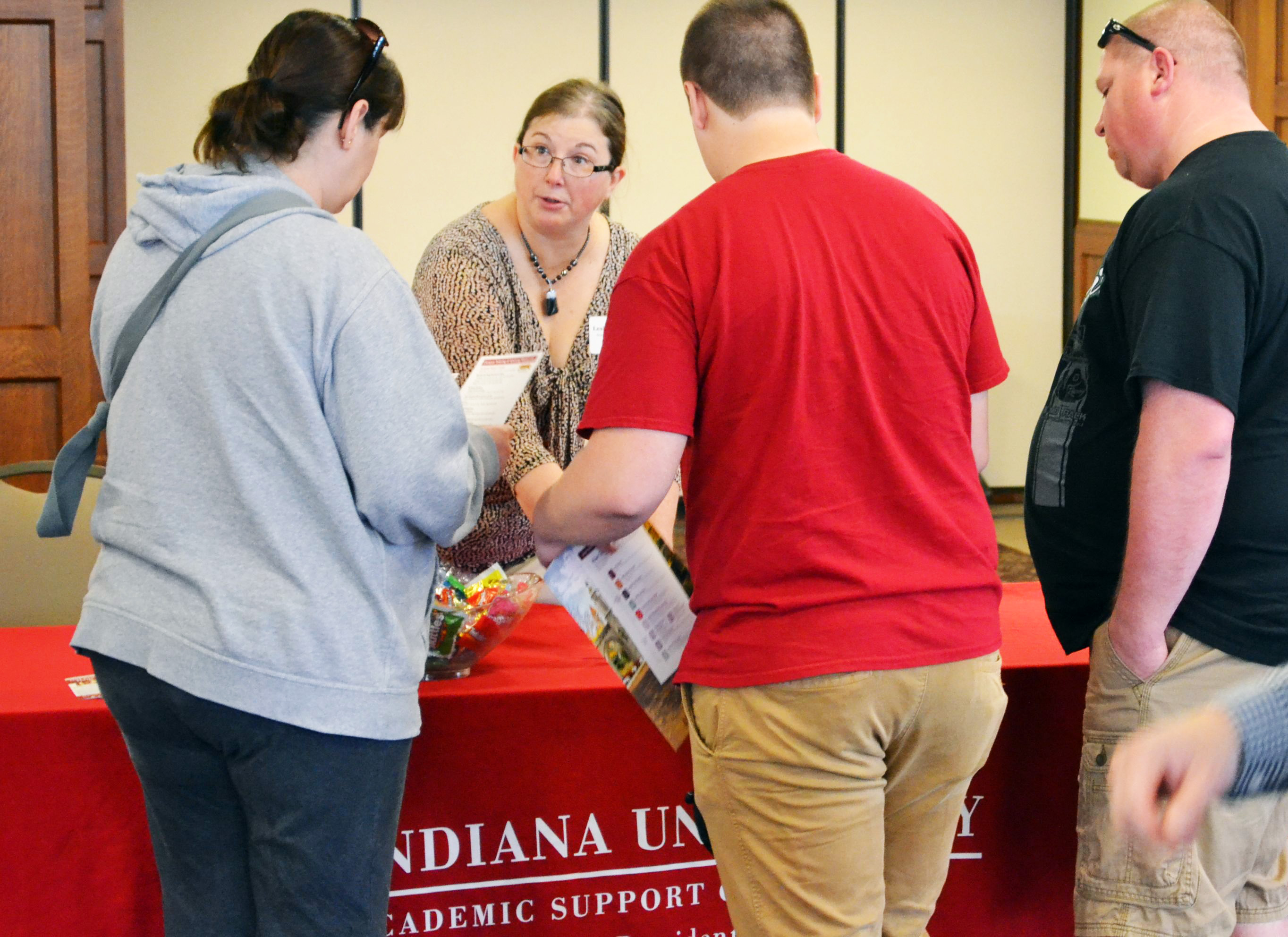 A family gathers resources at an information table.